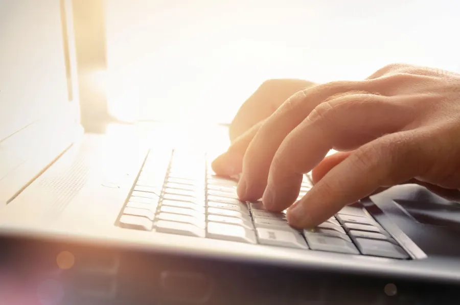 Typing a quote request on a laptop